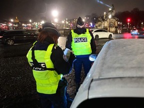 Police officers control the vehicles on the Concorde Square in Paris on Saturday, Jan. 16, 2021, during the nationwide 6 p.m. overnight curfew restrictions taken to curb the spread of the COVID-19 pandemic.