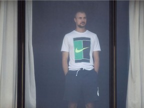 An unidentified tennis player looks out of the window after exercising in his hotel room in Melbourne in January 17, 2021, where players are quarantining for two weeks ahead of the Australian Open tennis tournament.