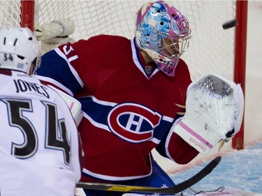 Carey Price (center) fails to stop Colorado Avalanche right wing David Jones (left) during NHL action at the Bell Centre in Montreal, October 15, 2011.