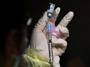 A pharmacist technician fills the Pfizer-BioNTech COVID-19 mRNA vaccine at a vaccine clinic during the COVID-19 pandemic in Toronto on Dec. 15, 2020.