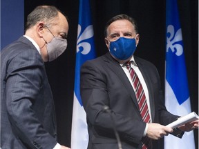 Quebec Premier Francois Legault, right, has a word with Health Minister Christian Dube as the leave the COVID-19 press briefing, Tuesday, January 26, 2021 in Montreal.