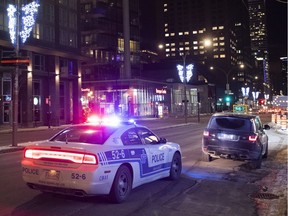 A car is pulled over by a police cruiser in Montreal on Jan. 9, 2021, as Quebec government's curfew comes into effect