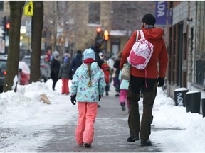 Parents walk their children to school as primary schools reopen following the Christmas break amid the COVID-19 pandemic in Montreal, on Monday, January 11, 2021.