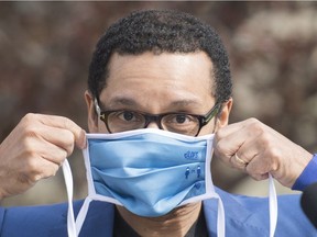 Quebec Junior Health Minister Lionel Carmant puts on a face mask following a news conference in Laval on May 17, 2020, as the COVID-19 pandemic continues in Canada and around the world.