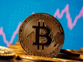 A representation of virtual currency Bitcoin is seen in front of a stock graph in this illustration taken Nov. 19, 2020.