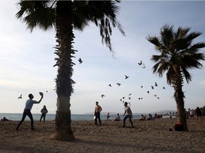 People enjoy the beach during an unusual warm day, amid the coronavirus disease (COVID-19) pandemic, in the southern suburb of Faliro in Athens, Greece, on Sunday, Jan. 10, 2021.