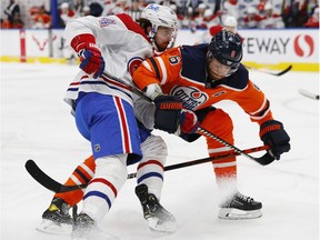 Montreal Canadiens centre Phillip Danault and Edmonton Oilers defencemen Adam Larssen battle for position during the second period at Rogers Place in Edmonton on Jan. 18, 2021.