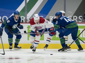 Jan 23, 2021; Vancouver, British Columbia, CAN; Vancouver Canucks forward Jake Virtanen (18) and forward Elias Pettersson (40) check Montreal Canadiens forward Nick Suzuki (14) in the first period at Rogers Arena. Mandatory Credit: Bob Frid-USA TODAY Sports