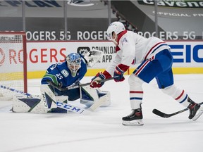 Canucks goalie Thatcher Demko makes a save on Canadiens forward Nick Suzuki during second period of Thursday night’s game at Rogers Arena in Vancouver.