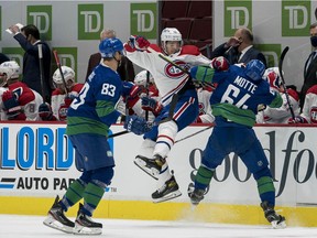 Canucks' Tyler Motte (64) checks Canadiens' Jesperi Kotkaniemi (15) as Vancouver forward Jay Beagle (83) looks on in the first period at Rogers Arena on Saturday, Jan 23, 2021, in Vancouver.