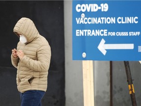 A man walks past the COVID-19 vaccination site at Maimonides long term care facility Wednesday, January 13, 2021 in Montreal.