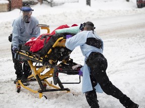 Urgences-santé paramedics fights with snow and cold as they load an elderly "COVID-19 suspect" case in to an ambulance in Montreal, on Saturday, January 16, 2021. "There may be a small benefit to colchicine in terms of reducing hospitalizations, but this benefit has to be weighed against side effects," Christopher Labos writes.