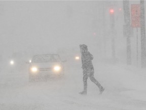 A pedestrian crosses a Montreal street during a winter storm Feb. 2, 2021.