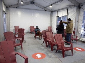 Organizers discuss how best to manage traffic flow in a new warming shelter inside a 40-by-25-foot tent in Cabot Square, in Montreal, on Wednesday, Feb. 3, 2021.