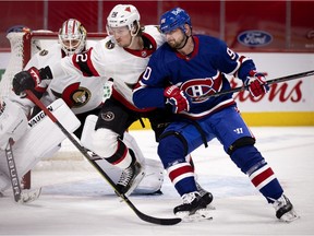 Montreal Canadiens left-wing Tomas Tatar gets pushed aside by Ottawa Senators defenceman Thomas Chabot as Ottawa Senators goaltender Matt Murray looks on in Montreal on Feb. 4, 2021.