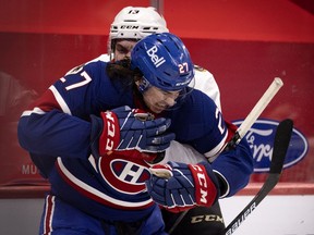 Canadiens defenceman Alexander Romanov reacts as Senators' Nick Paul grabs him Thursday night at the Bell Centre.