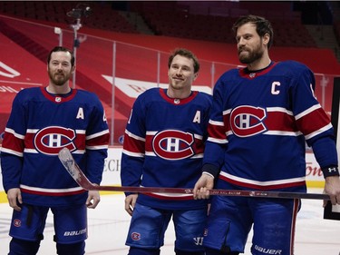 Montreal Canadiens defenseman Shea Weber (6) holds a silver stick presented by Montreal Canadiens left wing Paul Byron (41) and Montreal Canadiens right wing Brendan Gallagher (11) to mark his 1000th NHL game, at the Bell Centre in Montreal on Thursday, Feb. 4, 2021.