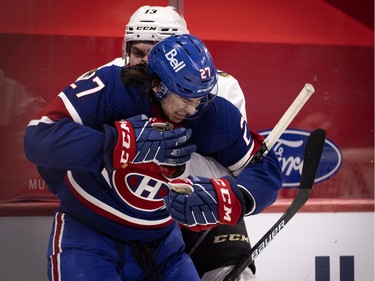 Montreal Canadiens defenseman Alexander Romanov (27) grimaces as Ottawa Senators left wing Nick Paul (13) grabs him and wrestles him to the ice at the Bell Centre in Montreal on Thursday, Feb. 4, 2021.