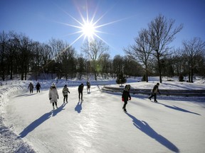 Skaters cast long shadows on sunny winter day at the rink on Mount Royal.