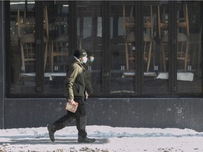 A man walks past a closed bar on St-Denis St. in February 2021, during the COVID-19 pandemic.