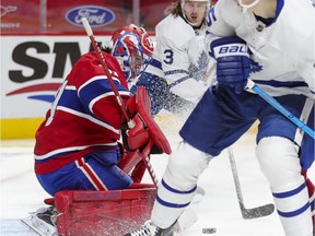 Carey Price tracks the puck under pressure from Toronto Maple Leafs' Justin Holl, rear, and Ilya Mikheyev during second period at the Bell Centre on Wednesday, Feb. 10, 2021.