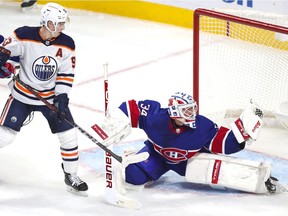 Montreal Canadiens goaltender Jake Allen makes a glove save as Edmonton Oilers Ryan Nugent-Hopkins looks for a rebound during the third period in Montreal on Feb. 11, 2021.