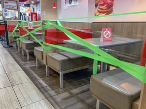 Tables and booths are wrapped in tape to keep customers from dining in a Burger King restaurant in Montreal on Wednesday, October 28, 2020.