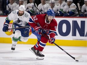 Montreal Canadiens left-wing Jonathan Drouin carries the puck over the blue line as Vancouver Canucks defenceman Jordie Benn (8) follows behind in Montreal on Feb. 1, 2021.
