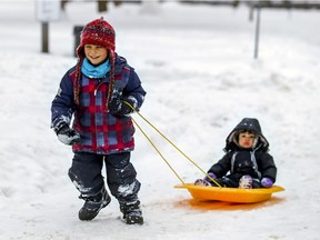 Jibran Khan pulls his sister Mira through Trenholme Park in the Notre-Dame-de-Grâce borough of Montreal Tuesday Feb. 16, 2021.