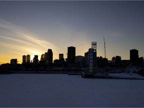 The sun sets behind the skyline of Montreal, on Feb. 17, 2021.