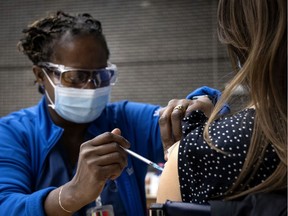 Nurse Gina Valcourt administers a vaccine in Montreal.