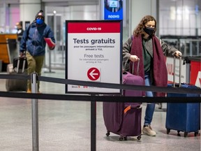 Travellers arrive at Montréal–Trudeau International Airport on Feb. 21, 2021.  As of Monday, all travellers arriving in Canada must quarantine in a government-designated hotel for three days while they await results of a COVID-19 test.