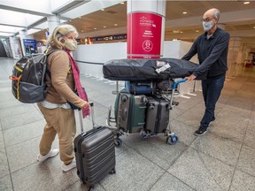 Danielle Beaudoin and husband Serge Gauthier arrive at Trudeau airport on Sunday. The couple cut short their winter stay in the Dominican Republic to avoid the new mandatory hotel quarantine, which came into effect the following day.