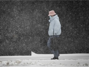 Walking along Rene Levesque near Stanley during afternoon snowfall on Monday, February 22, 2021.