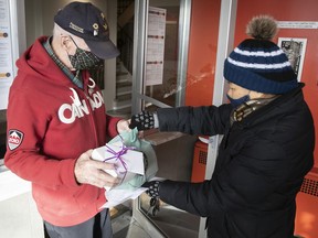 Mary Fong (right) delivers food to Dorval resident Bruce Udle as part of her volunteer rounds for Volunteer West Island on Feb. 18, during the COVID-19 pandemic.
