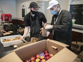 James Barrington, left, from the Depot Community Food Centre and Gabriel Faraone from Mission Bon Accueil prepare food bags at the depot.