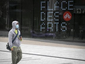 A man wearing a mask walks past Place des Arts on Wednesday September 30, 2020 during the COVID-19 pandemic. The concert hall will shut its doors as of midnight tonight because of government decree for 28 days. (Pierre Obendrauf / MONTREAL GAZETTE) ORG XMIT: 65085 - 8042