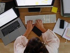 A woman works at a desktop computer alongside an Apple Inc. laptop in a home office in this arranged photograph taken Saturday, Aug. 22, 2020.