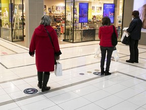 Clients stand in line in front of a cosmetics store in the Champlain Mall in Brossard in December.