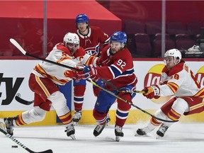 Jonathan Drouin of the Montreal Canadiens tries to skate past Mark Giordano, left, and Andrew Mangiapane of the Calgary Flames during the second period at the Bell Centre on Jan. 30, 2021 in Montreal.