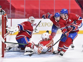 Goaltender Jake Allen of the Montreal Canadiens makes a skate save as teammates Alexander Romanov and Brendan Gallagher, right, defend against Joakim Nordstrom of the Calgary Flames during the third period at the Bell Centre on Jan. 30, 2021, in Montreal.
