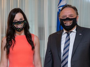 Media personality Rosalie Taillefer-Simard wears a mask with a transparent window alongside Quebec Premier François Legault last year.