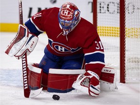 Montreal Canadiens goaltender Carey Price (31) pulls in a puck to cover up during NHL action against the Vancouver Canucks in Montreal Feb. 1, 2021.