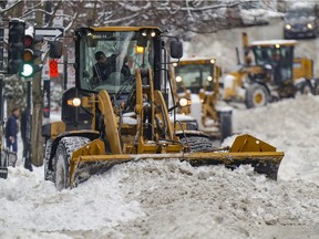 Heavy snow removal equipment plows throw the latest snowfall in Montreal.