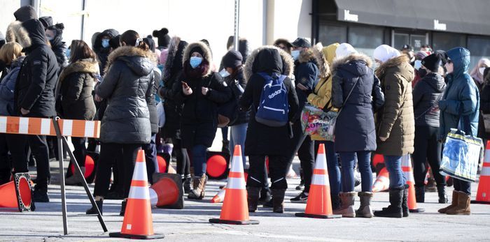 People line up ahead of reopening to enter the Winners store at Marche Centrale in Montreal Feb. 8, 2021.