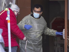 A security guard offers to help an elderly woman down the stairs at the Parc Ave Covid-19 testing site in Montreal on Friday, February 26, 2021.  (Allen McInnis / MONTREAL GAZETTE) ORG XMIT: 65809