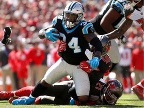 Running-back Cameron Artis-Payne of the Carolina Panthers is brought down by middle linebacker Kwon Alexander and strong safety Justin Evans of the Tampa Bay Buccaneers during first quarter on Oct. 29, 2017, at Raymond James Stadium in Tampa.