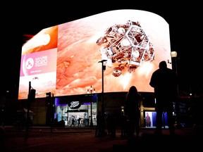 A simulation of the landing of NASA's Perseverance rover on the planet Mars, where it will look for signs of past microbial life, cache rock and soil samples, and prepare for future human exploration, is livestreamed on the Piccadilly Lights screen in central London Feb. 18, 2021.