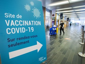 A cleaner walks through the empty halls of a mass COVID-19 vaccination sites in Montreal.