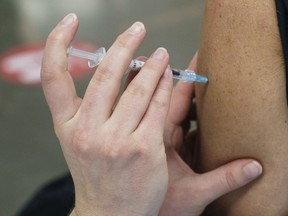 A woman receives her COVID-19 vaccine at a vaccination clinic in Montreal's Olympic Stadium on Tuesday, February 23, 2021.